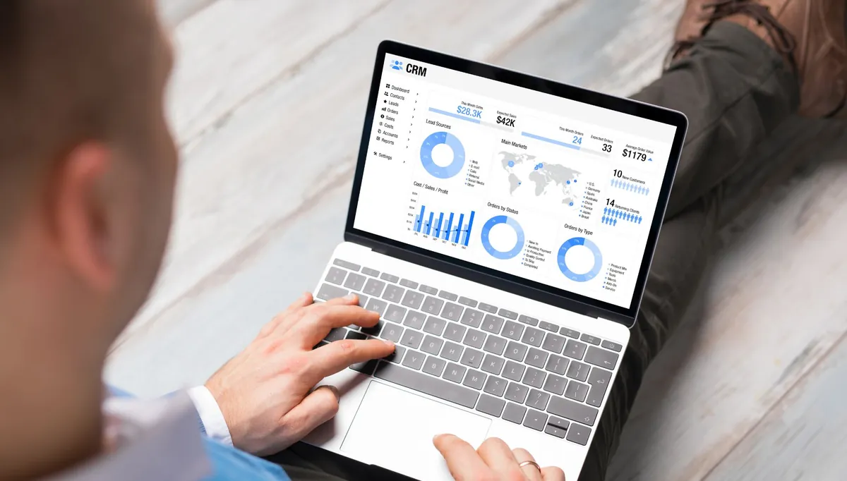 Mãos operando notebook que exibe gráficos de desempenho